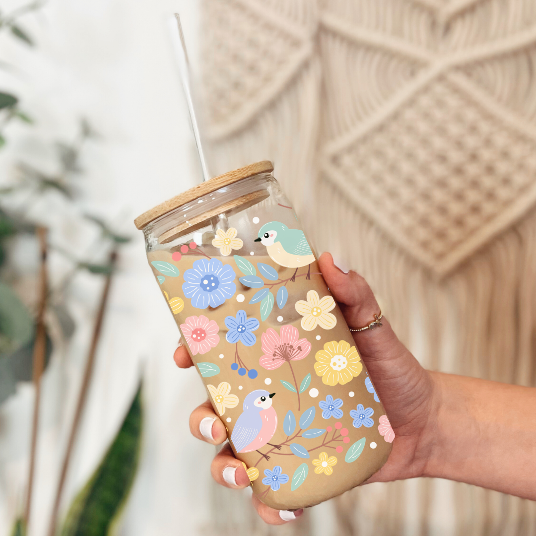 Gros plan sur l'imprimé d'un petit oiseau bleu et de fleurs roses en relief sur le verre clair.