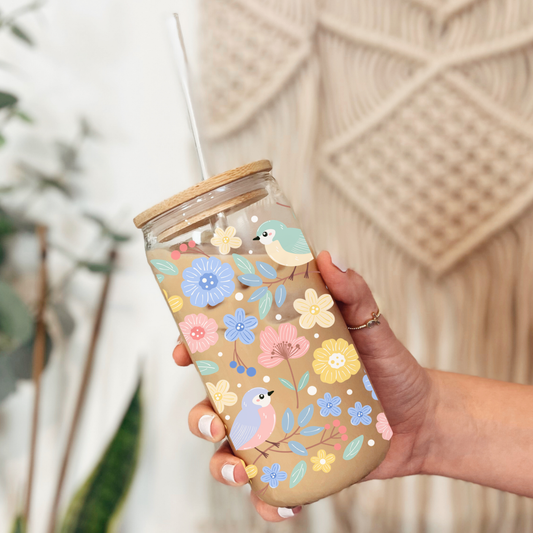 Gros plan sur l'imprimé d'un petit oiseau bleu et de fleurs roses en relief sur le verre clair.