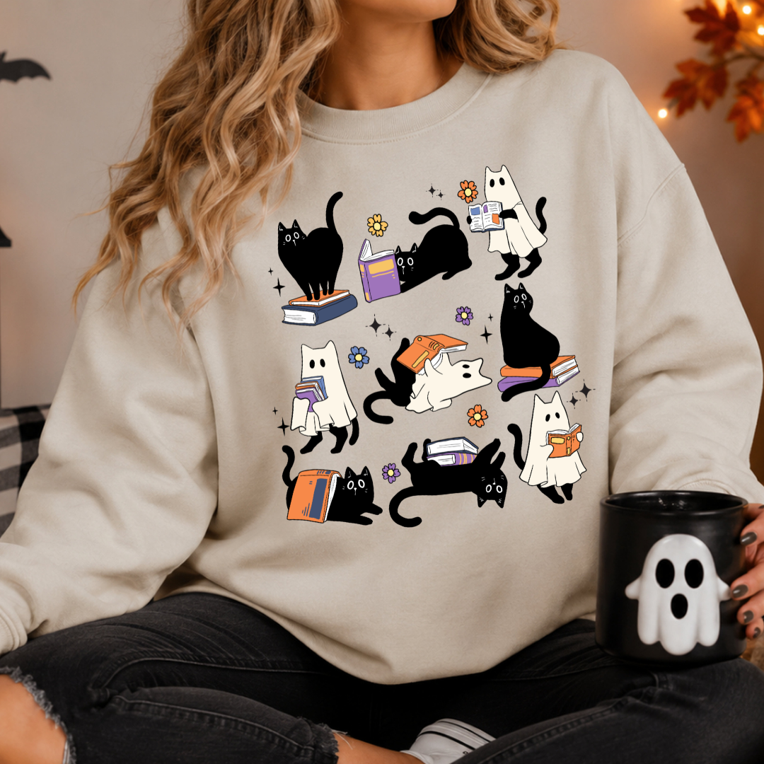 Sweatshirt unisexe en coton avec un motif de chats noirs fantômes qui lisent des livres pour Halloween.