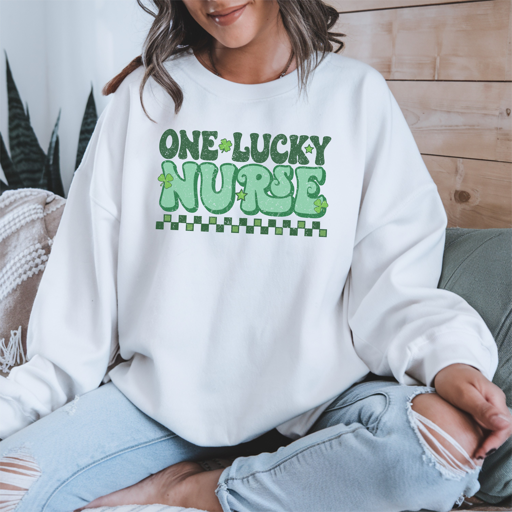 Sweatshirt Gildan blanc avec design rétro « One Lucky Nurse » décoré de trèfles, parfait pour la Saint-Patrick de couleur vert.