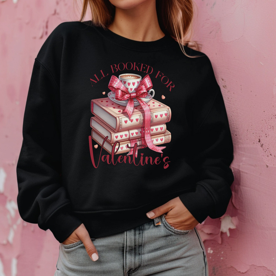 Mannequin portant un sweatshirt noir avec un design  “All Booked for Valentine’s”, illustré par une pile de livres décorés de cœurs et une tasse de café, style romantique et cosy.