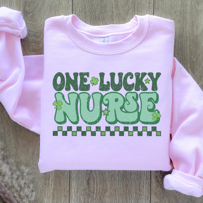 Sweatshirt Gildan Rose avec design vert rétro « One Lucky Nurse » décoré de trèfles, parfait pour la Saint-Patrick.
