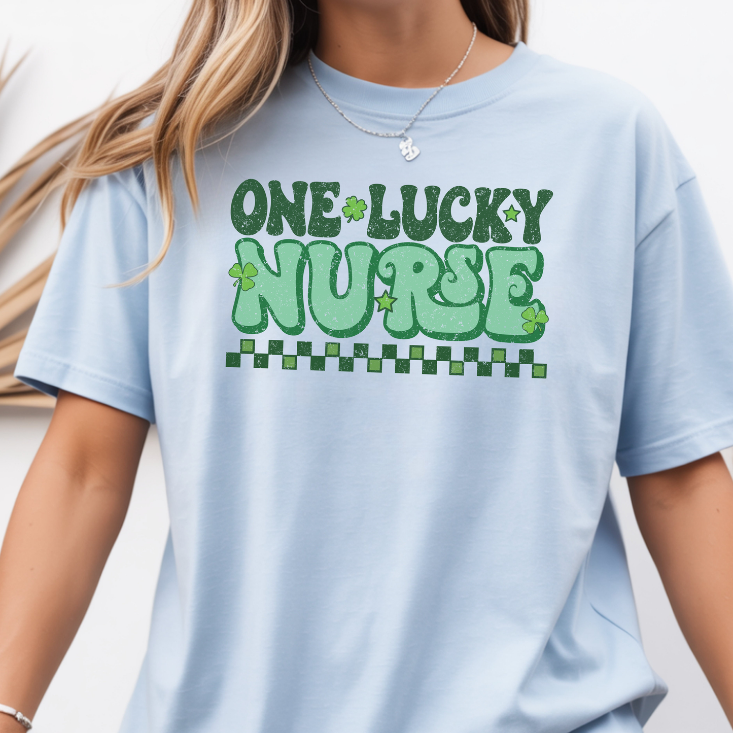 T-shirt Gildan bleu pâle avec design vert rétro « One Lucky Nurse » décoré de trèfles, parfait pour la Saint-Patrick.