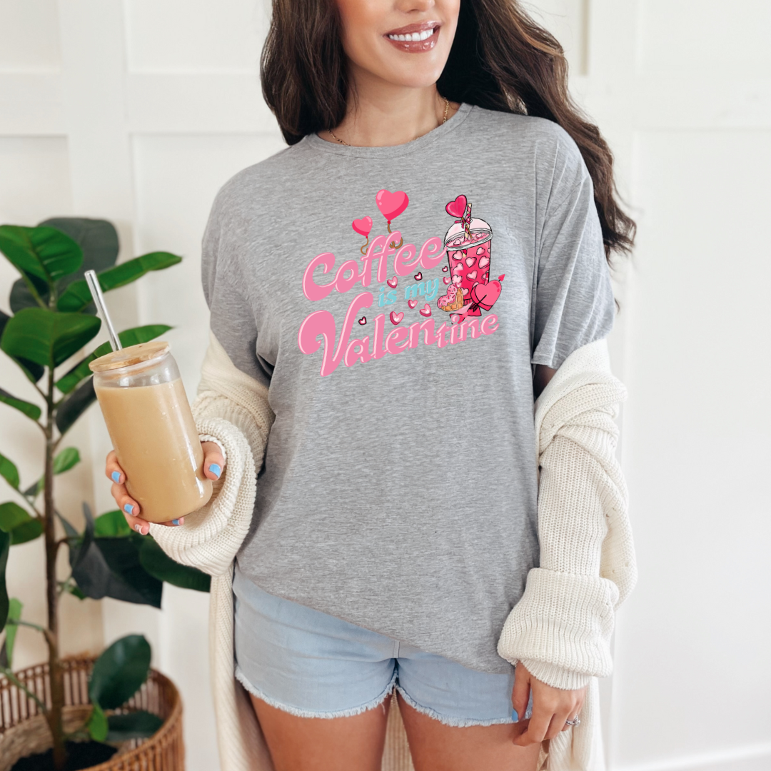Mannequin portant un T-shirt Gildan Gris Athlétique avec design de la St-Valentin ''Coffee is my Valentine'' avec un verre de café glacé aux couleurs rose.