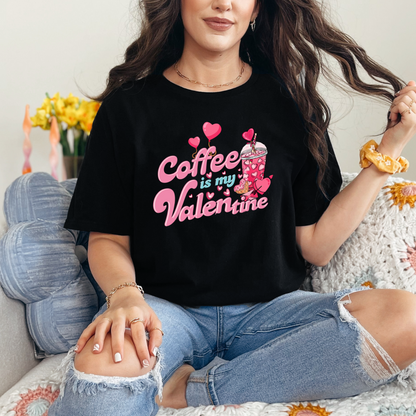 Mannequin portant un T-shirt Gildan noir avec design de la St-Valentin ''Coffee is my Valentine'' avec un verre de café glacé aux couleurs rose.
