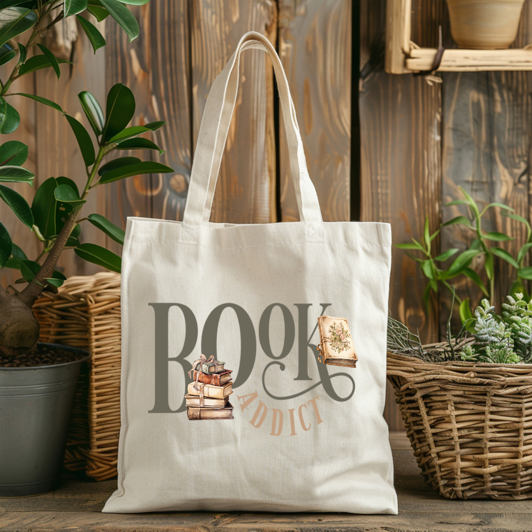 Sac fourre-tout de couleur naturel en coton 15 x 16 pouces de diamètre avec design de livres et l'inscription Book Addict. Pour amateur de lecture et de livres.