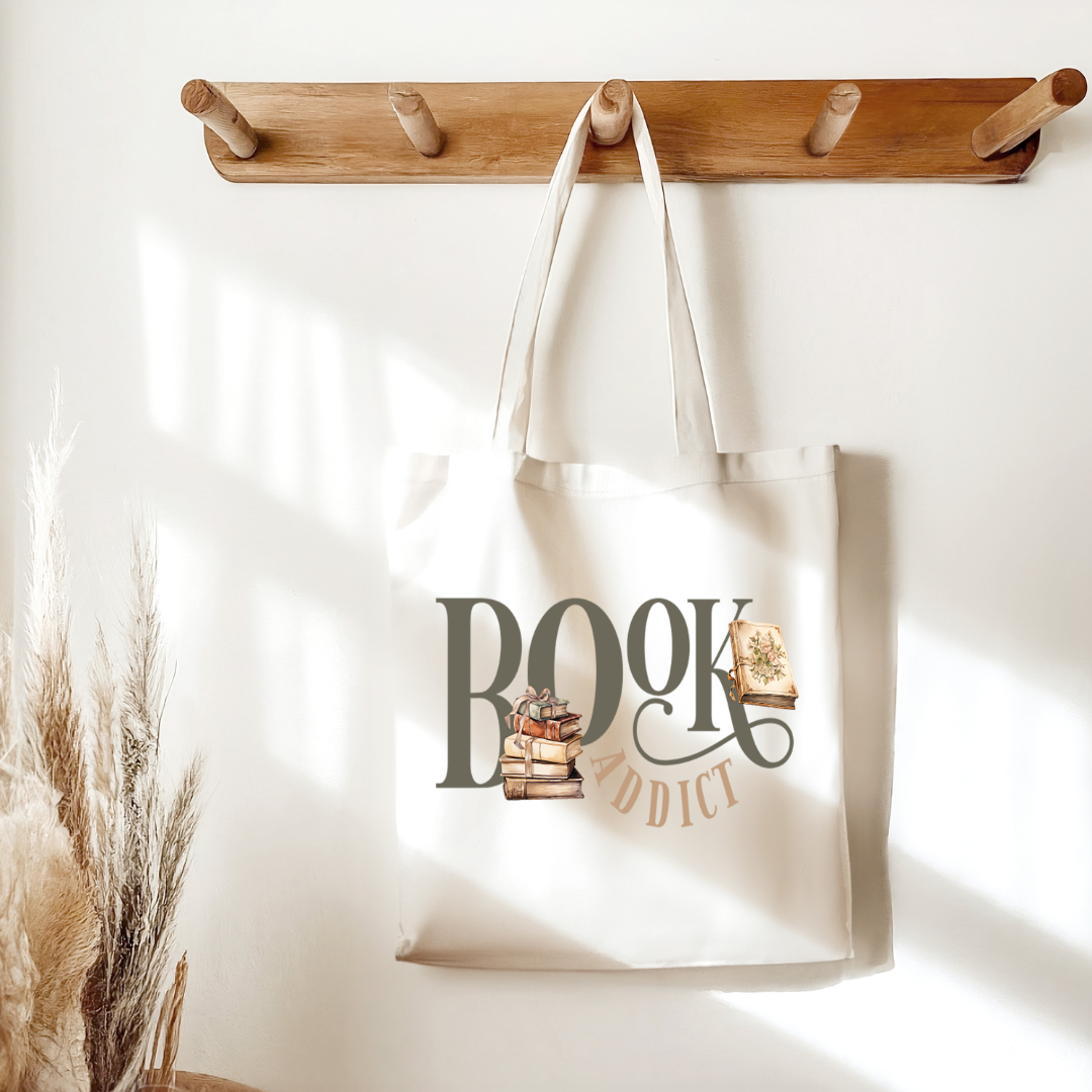 Sac fourre-tout de couleur naturel en coton 15 x 16 pouces de diamètre avec design de livres et l'inscription Book Addict. Pour amateur de lecture et de livres.