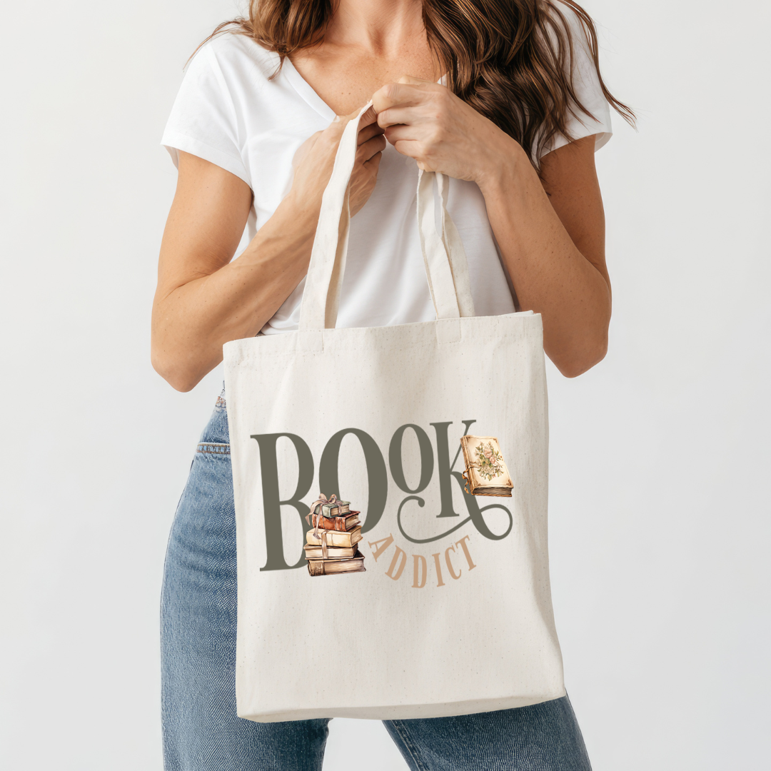 Sac fourre-tout de couleur naturel en coton 15 x 16 pouces de diamètre avec design de livres et l'inscription Book Addict. Pour amateur de lecture et de livres.