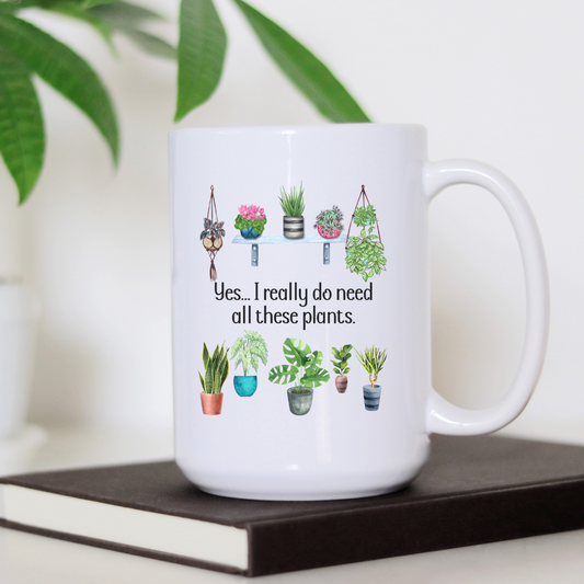 Tasse blanche 15 oz avec illustrations de diverses plantes en pots et inscription humoristique "Yes, I really do need all these plants" sur fond blanc.
