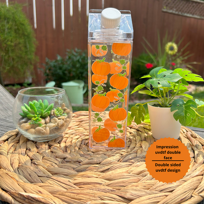 Bouteille transparente de 500 ml en forme de carton de lait avec un motif de petites citrouilles orange et noires pour Halloween.