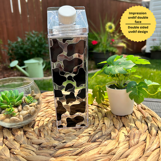 Bouteille transparente de 500 ml style carton de lait avec un motif de taches de vache noires sur tout le contour.