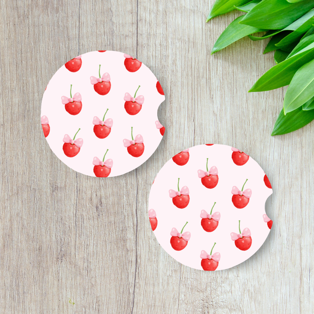 Duo de sous-verres pour voiture motif cerises rouges sur fond rose pastel

