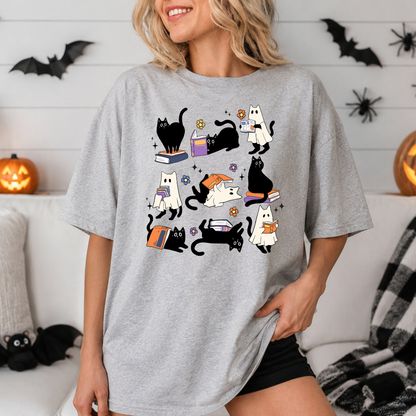T-shirt unisexe en coton avec un motif d'un chat noir et d'un fantôme qui lisent des livres pour Halloween.