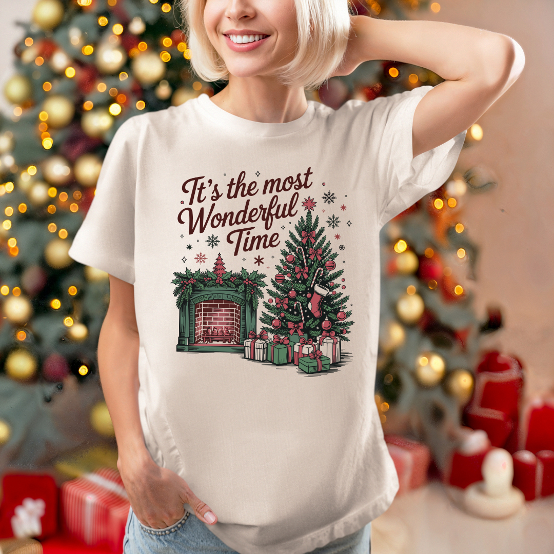 T-shirt de couleur sable avec Illustration festive d’un sapin décoré et d’une cheminée illuminée, ambiance vintage et chaleureuse pour Noël.