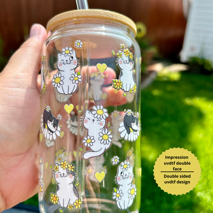 Verre à café glacé 16 oz avec motifs de chatons noirs et blancs et marguerites jaunes, tenu à la main à l'extérieur avec couvercle en bambou et paille.