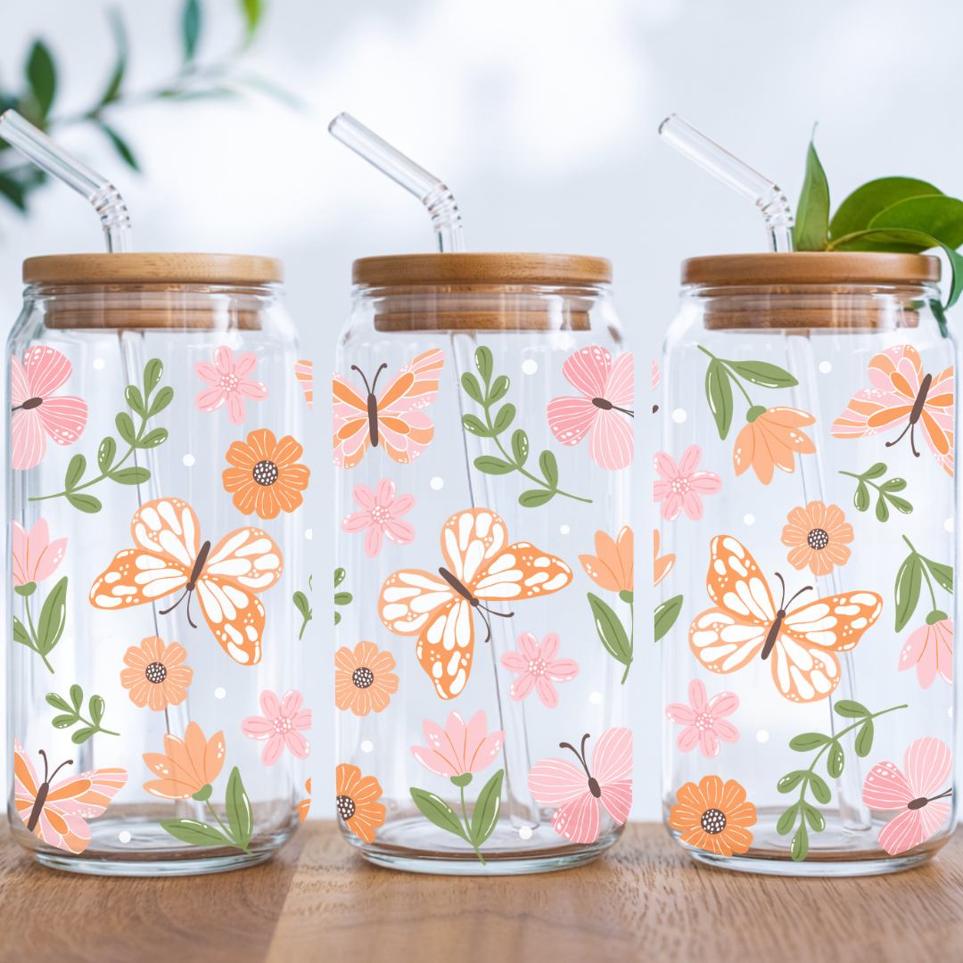 Verre à café glacé transparent de 16 oz orné de motifs botaniques de papillons et jardin de fleurs sauvages, avec couvercle en bambou et paille en verre.