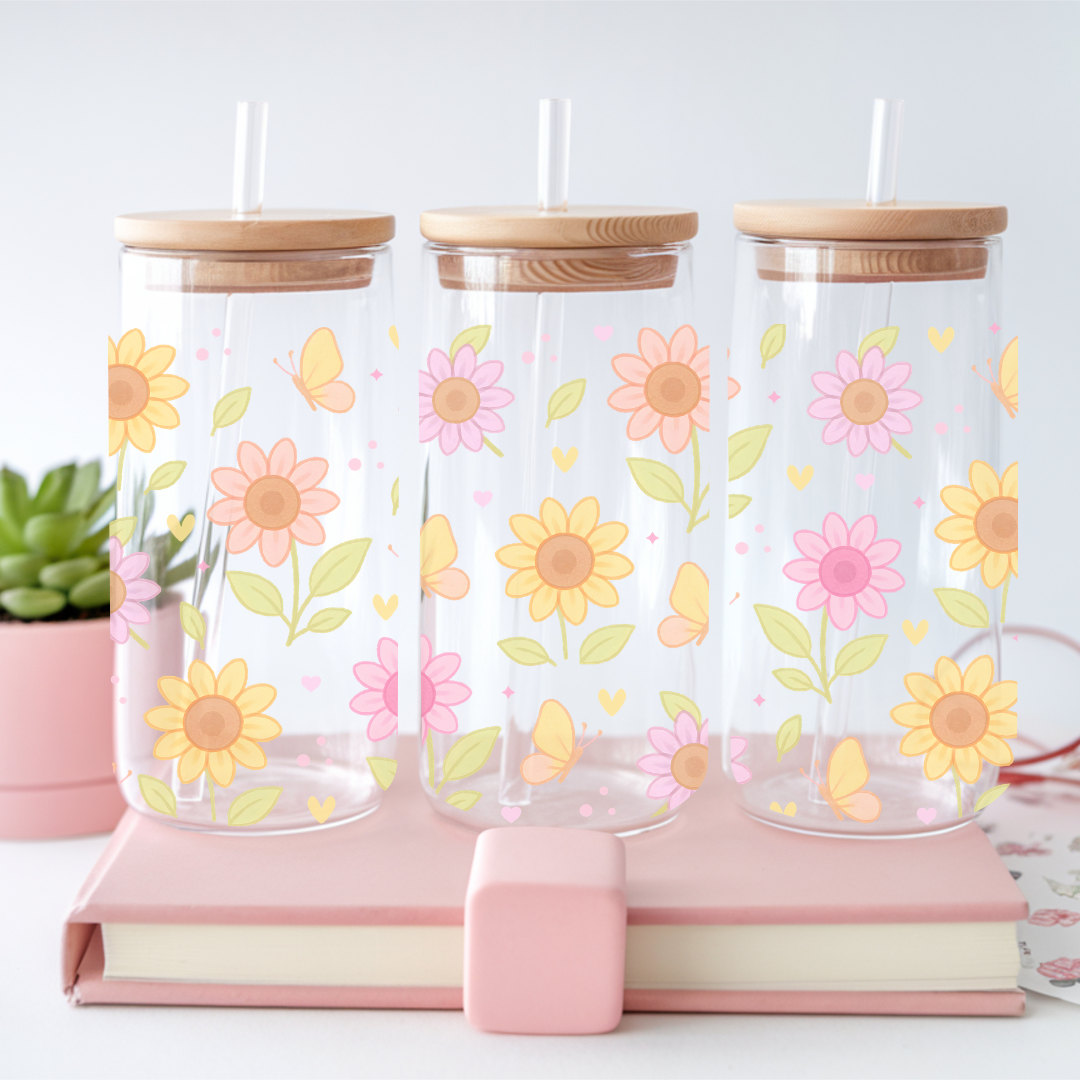 Verre à café glacé transparent de 16 oz orné de motifs de grands tournesols aux couleurs pastels et papillons, avec couvercle en bambou et paille en verre.